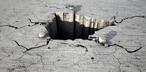 A deep hole cracked out of a flat piece of cracked stone