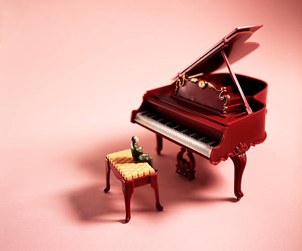 istock Small Man Sitting at Grand Piano 536511505