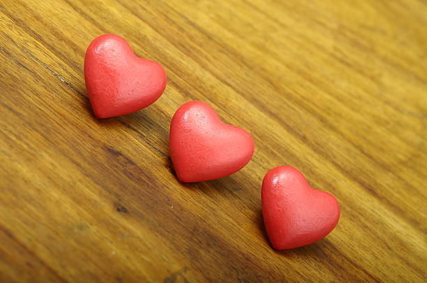 istock Three red heart on wooden background 536552869