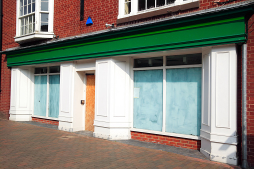 Bankrupt closed down retail shop, with whitewashed windows, at a pedestrian shopping centre