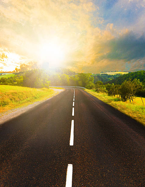 Sunset in nature with endless road leading towards forests