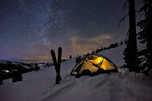 Tent and Skis in Winter Backcountry with Milky Way - Backcountry winter ski mountaineering campsite located at tree line in the Gore Range backcountry, Colorado USA.