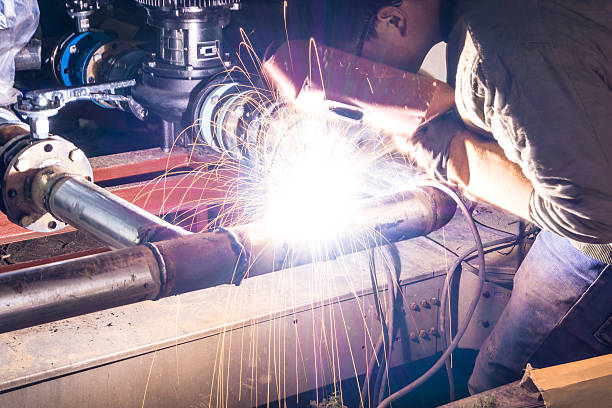 welder welding pipeline at night