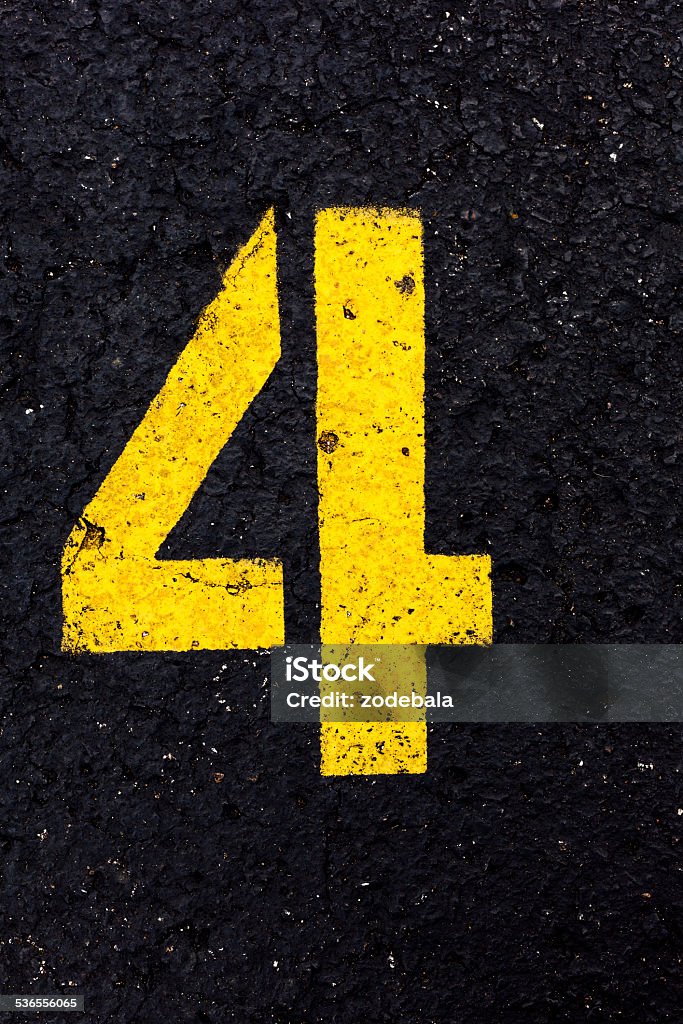 Yellow Number Four on Asphalt Number four painted on asphalt 2015 Stock Photo