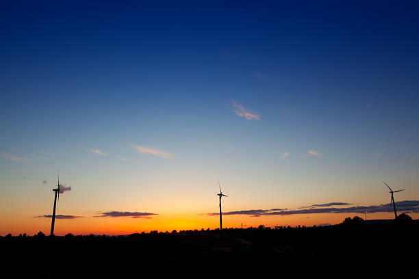 istock Blue orange sunset with electric windmills 536557277