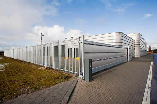 Secure metal industrial building Well secured metal industrial building fence stock pictures, royalty-free photos & images