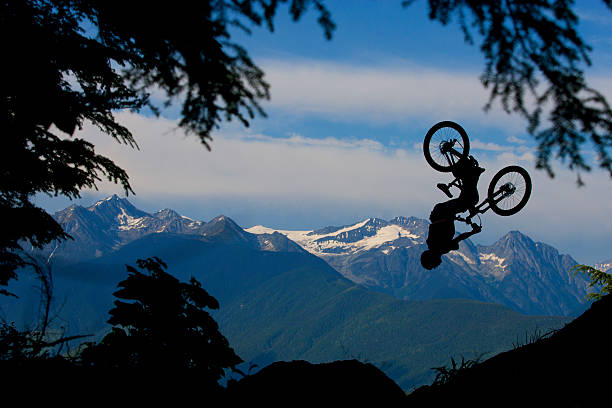 горный велосипед спине flip - skill side view jumping mid air стоковые фото и изображения