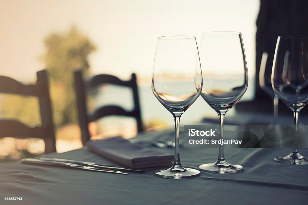 Lunch by the sea Glasses on the restaurant table near the sea 2015 Stock Photo