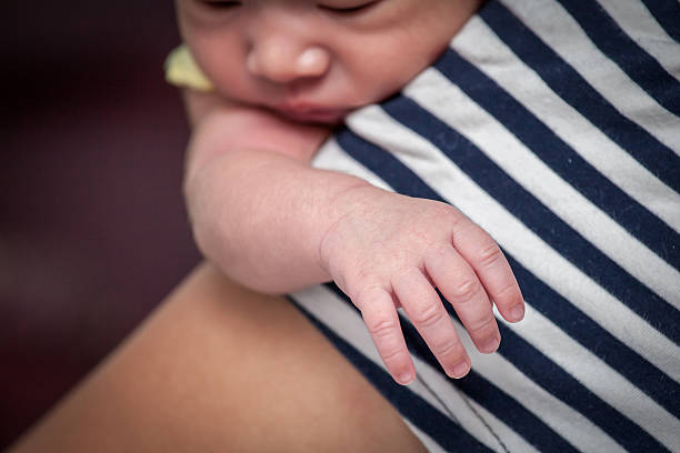 skupić się na nowo narodzony noworodek płci męskiej ręki na jego matka na ramię - facial expression babies and children head and shoulders close up zdjęcia i obrazy z banku zdjęć