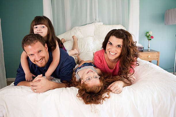 istock Happy Sisters Lying on Bed with Dad and Mom 536610265