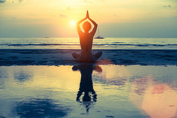 istock Young woman practicing yoga on the beach at surrealistic sunset. 536613077