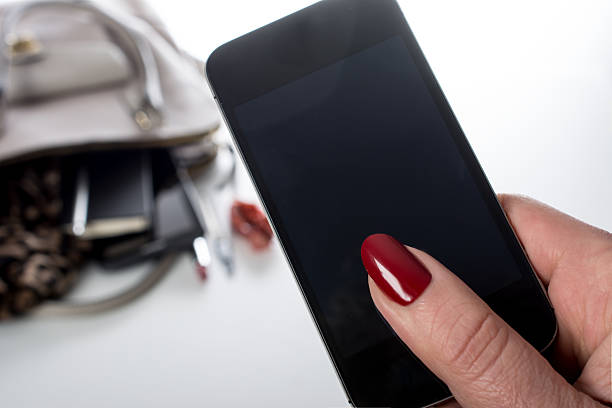 Mature woman holds phone with clipping path (display)
