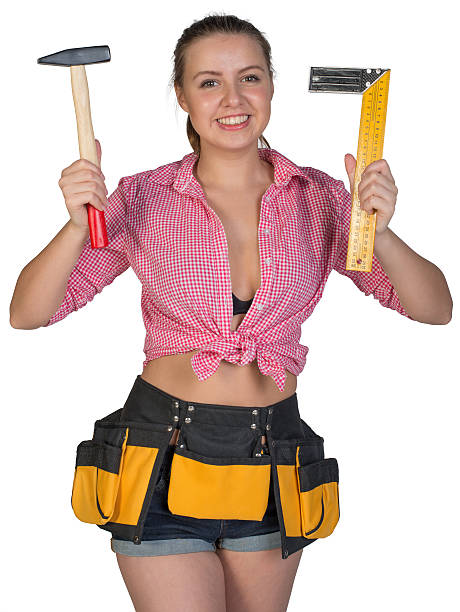 istock Woman in tool belt holding hammer and angle ruler 536614841