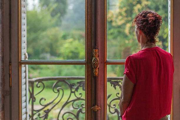 istock Daydreaming while looking out a window to a lush garden 536655980