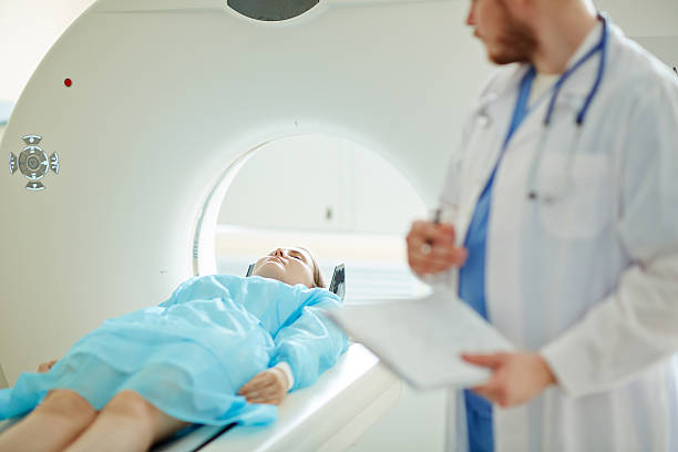 Computer tomography Doctor examining female patient with CT scanner tomography stock pictures, royalty-free photos & images