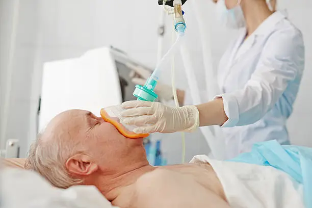 Doctor applying oxygen mask on senior patient