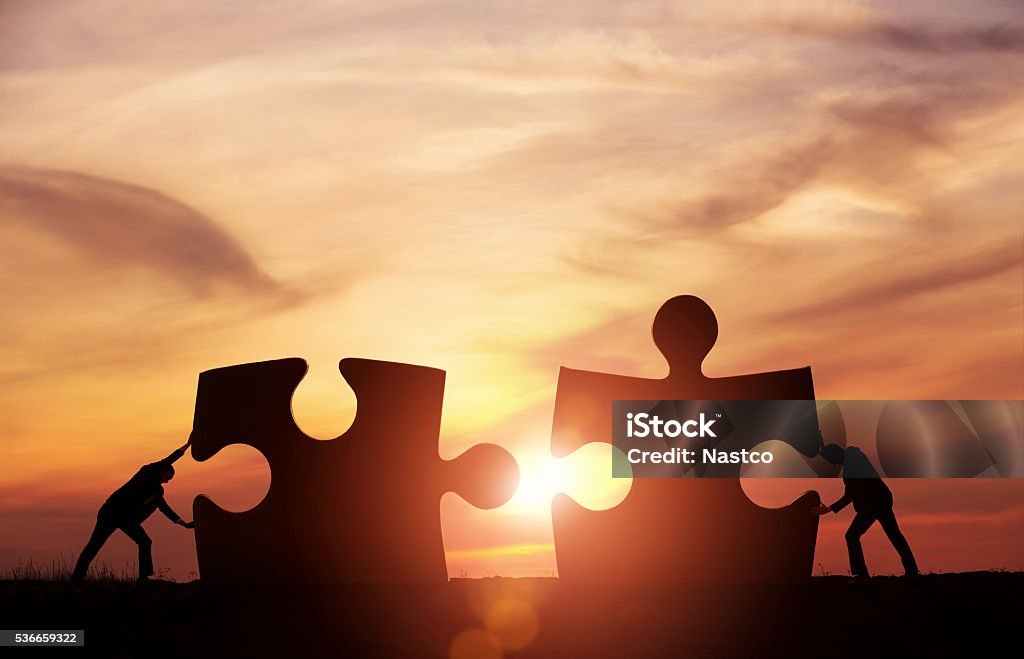 Teamwork concept Two businessman connecting puzzle pieces togheter with copy space Togetherness Stock Photo