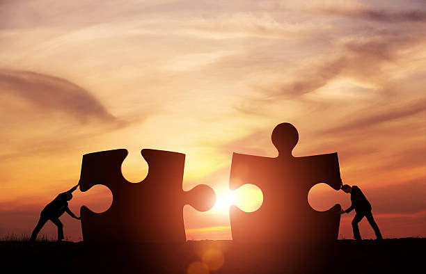 Teamwork concept Two businessman connecting puzzle pieces togheter with copy space the end words stock pictures, royalty-free photos & images