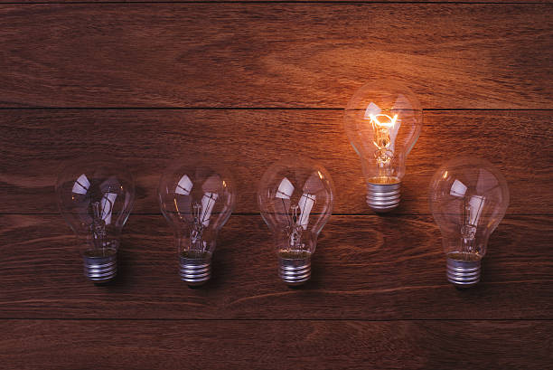 istock Incandescent lamps glowing on wooden background 536660558