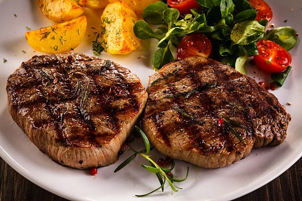 istock Beef steaks, baked potatoes and vegetable salad 536665822