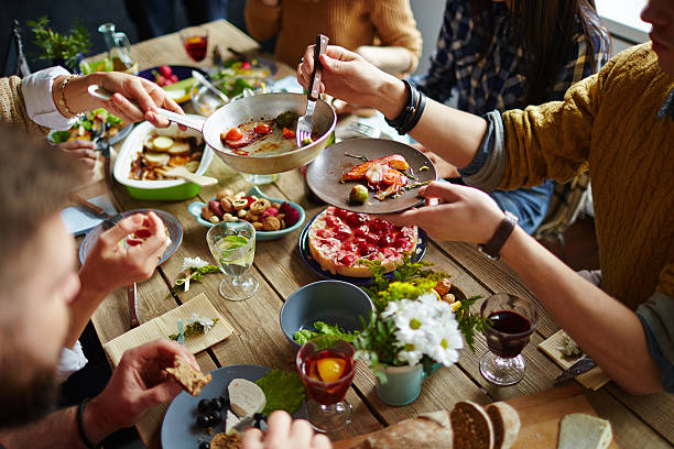 Family dinner People sitting at dining table and eating sharing stock pictures, royalty-free photos & images