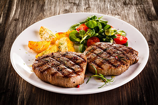 bifes de carne de bovino, batatas assadas e salada de vegetais - steak grilled beef plate imagens e fotografias de stock