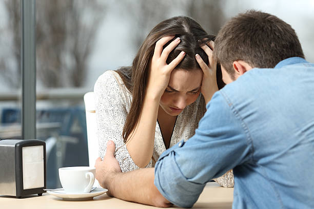 Man comforting a sad depressed girl Male comforting to a sad depressed female who needs help in a coffee shop. Break up or best friend concept clingy girlfriend stock pictures, royalty-free photos & images
