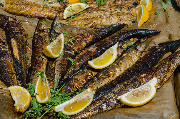 Grilled sea fish with lemons and greenery