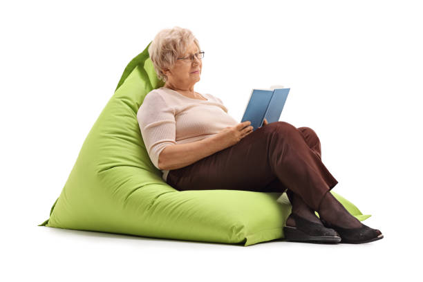 istock Mature lady reading book seated on beanbag 536674874
