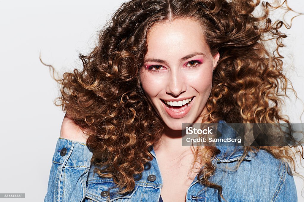 Beautiful brunette model smiling at camera Curly Hair Stock Photo