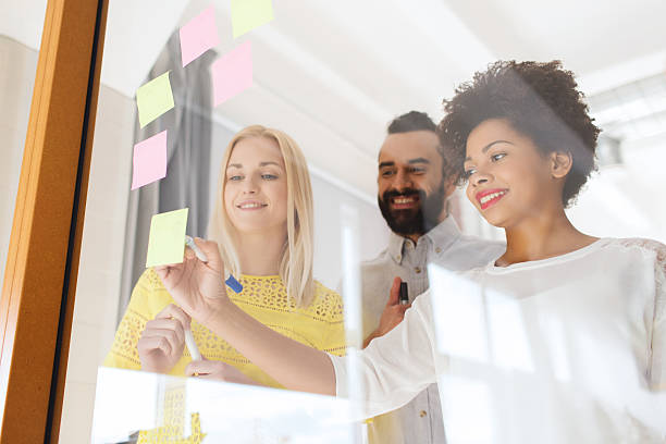 istock happy creative team writing on stickers at office 536676634