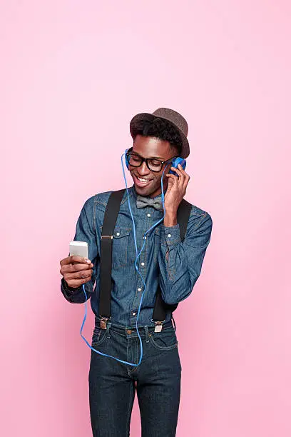 Photo of Happy afro american guy listen to music using smart phone