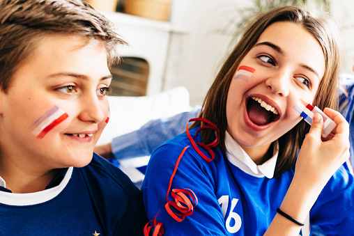 french sister kids  in soccer outfit with tricolore face painting