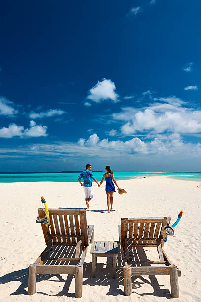 coppia in esecuzione su una spiaggia alle maldive - chair beach chaise longue isolated foto e immagini stock