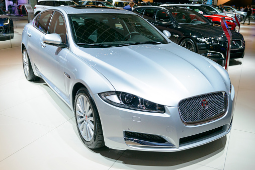 Brussels, Belgium - January 15, 2015: Jaguar XF saloon car on display during the 2015 Brussels motor show. People in the background are looking at the cars.