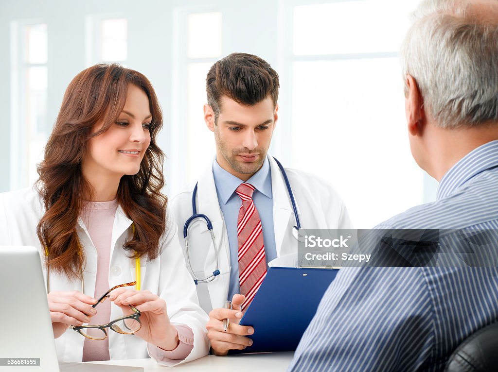 Medical team with elderly patient Femal doctor and male doctor consulting from medical test result with senior patient at nursing home. 2015 Stock Photo