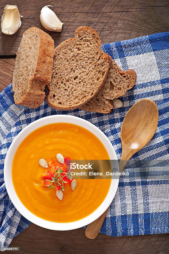 Delicious cream of pumpkin soup in a bowl Delicious cream of pumpkin soup in a bowl on wooden tableDelicious cream of pumpkin soup in a bowl on wooden table 2015 Stock Photo