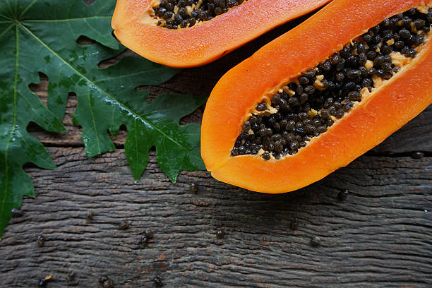 istock papaya with green leaf on old wooden background. 536683110