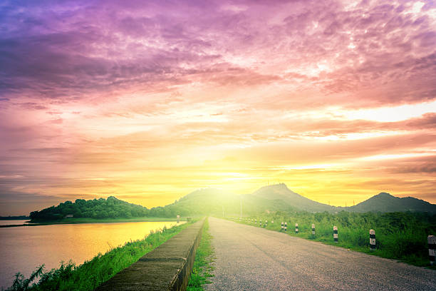 istock Long road through big lake, Dramatic sunset over the lake 536684126