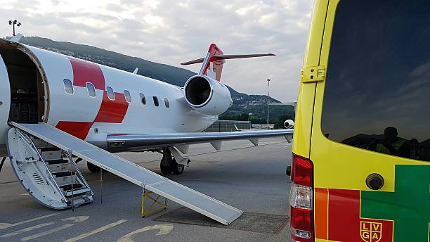 Air ambulance meets road ambulance Lugano, Switzerland - May 26 2016: Rega's Canadair 640 on the tarmac during an emergency patient transfer aircraft in lugano airport stock pictures, royalty-free photos & images