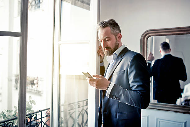 istock bearded business man reading on smartphone at opened window 536684500