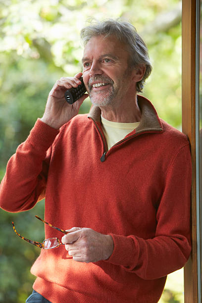 Mature Man Using Cordless Phone At Home stock photo