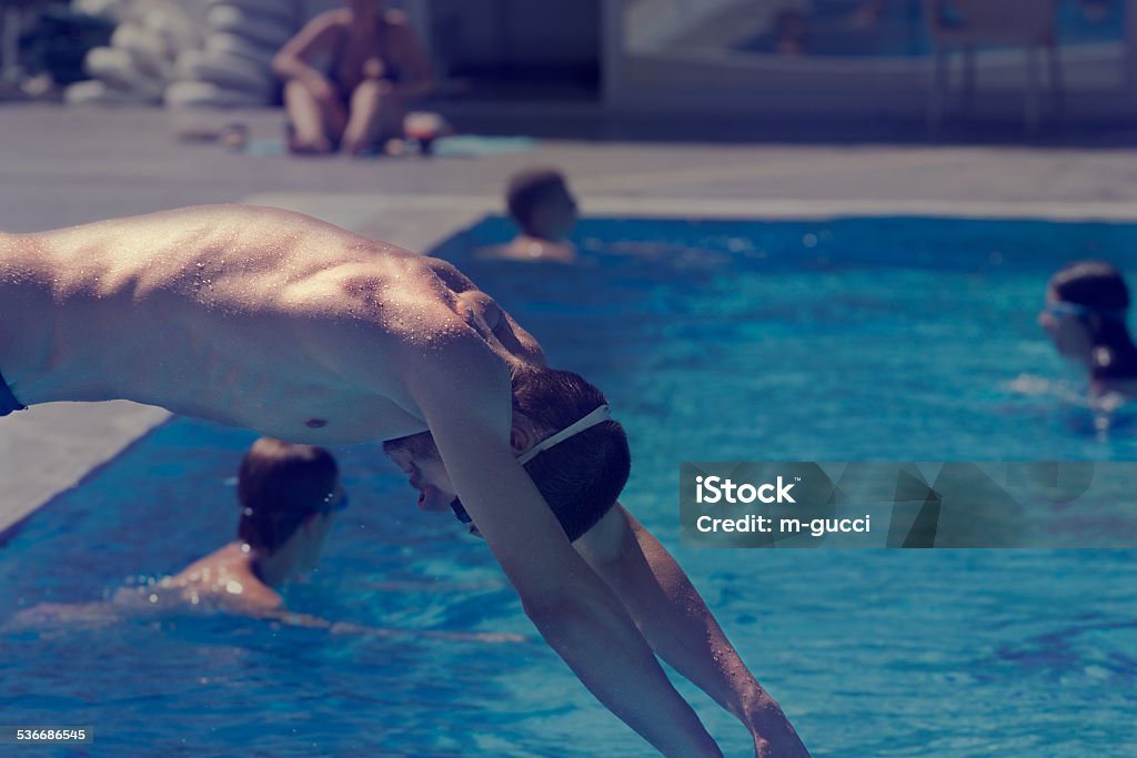 Jumping into the pool Well built sportsman jumping itno the pool. Swimming Stock Photo