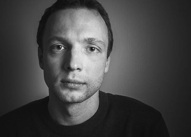 Young serious Caucasian man, closeup lo-key