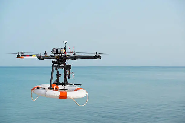 Radio control octocopter (Drone/ UAV) in the air carrying life ring to rescue active drowning victim.