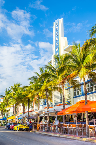 Miami Beach, Florida, USA - April 25, 2016:   View along Ocean Drive along South Beach Miami in the historic Art Deco District with hotels, restaurant, people and luxury cars visible.  South Beach has been  a notable tourist destinations for many years. 