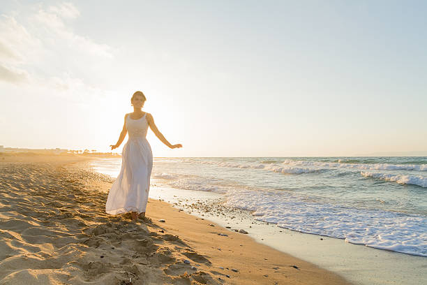 istock Young woman enjoys walking on a hazy beach at dusk. 536722103
