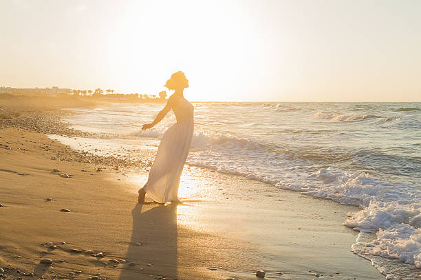 istock Young woman enjoys walking on a hazy beach at dusk. 536722149