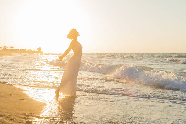 istock Young woman enjoys walking on a hazy beach at dusk. 536722205