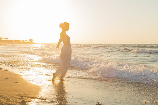 istock Young woman enjoys walking on a hazy beach at dusk. 536722271